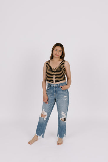 Girl wearing jeans and tan and black striped top