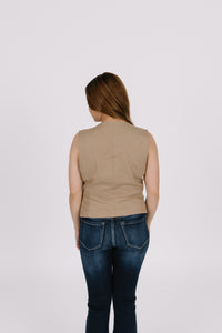 Girl wearing tan vest with jeans