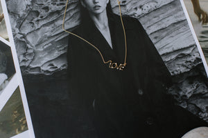 A picture of girl wearing gold love necklace